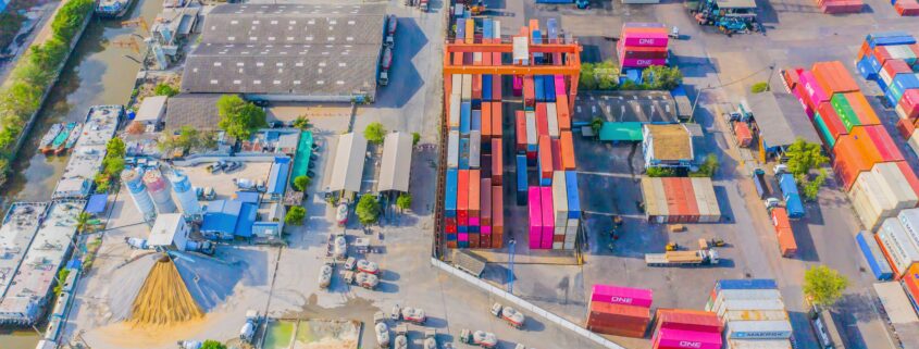 global supply chain shipping container loading site viewed from the air.